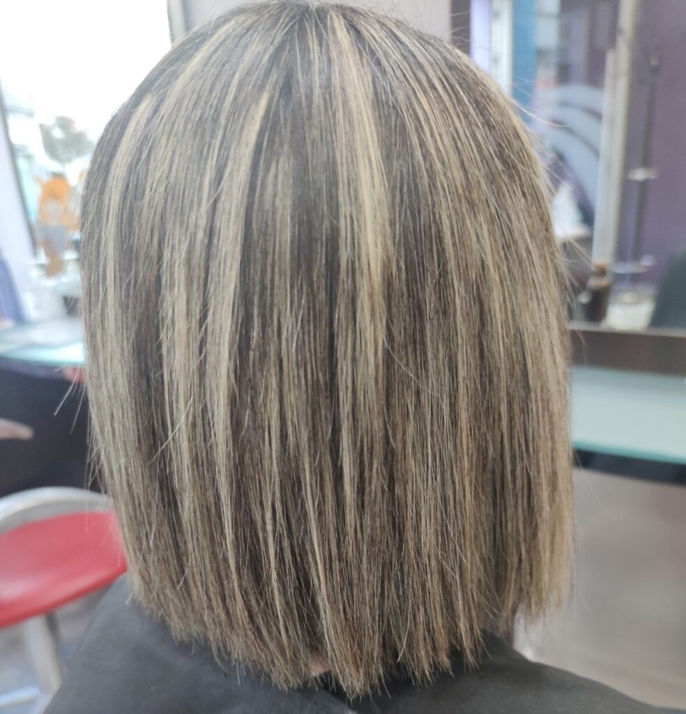 Melena larga con mechas rubias y raíz natural en Peluquería Ana Boiro